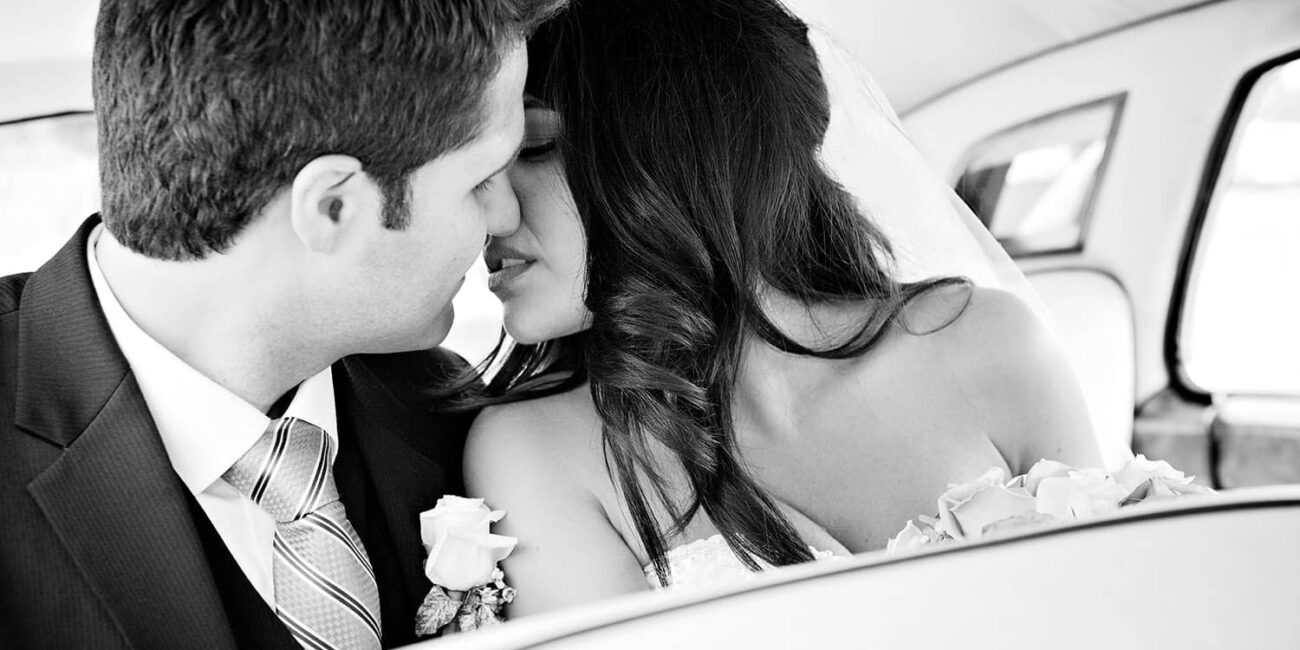 Romantic Toronto wedding photography of couple kissing in wedding limousine Rolls Royce